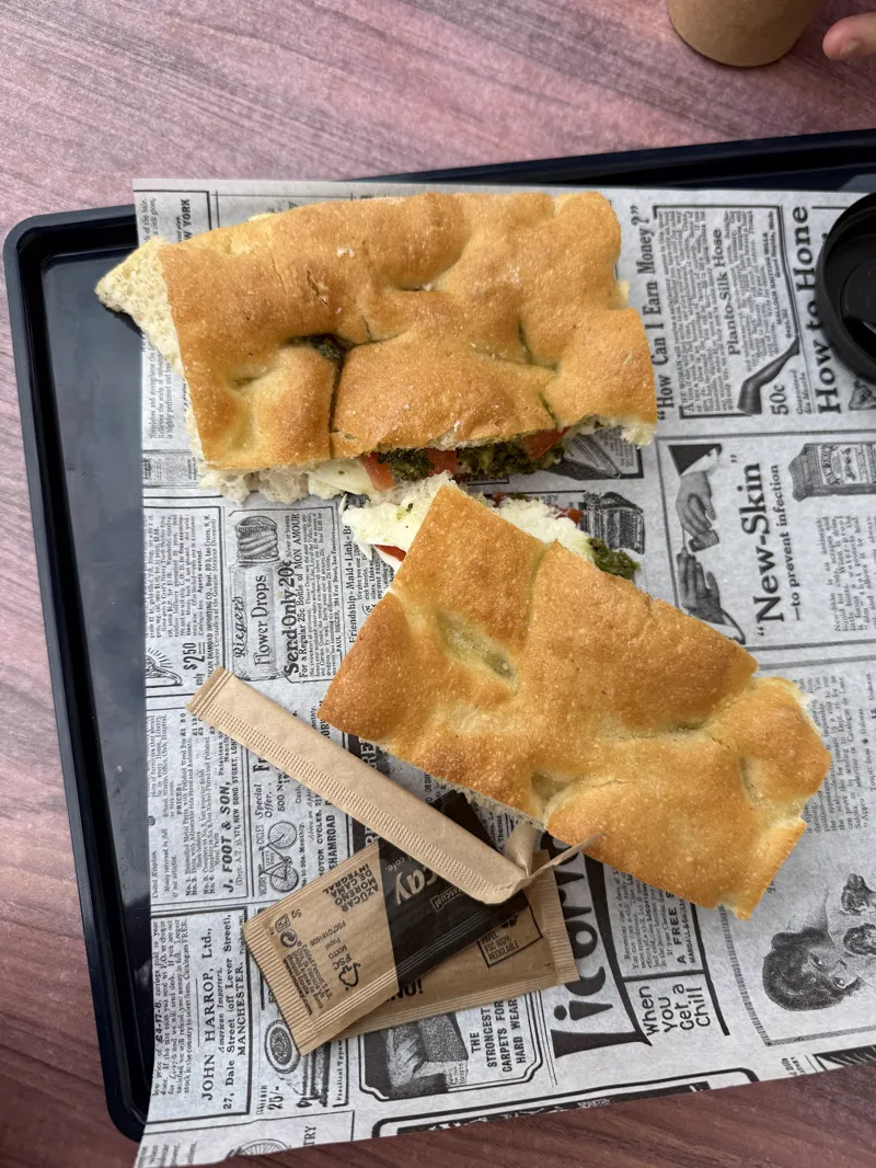Focaccia abierta y rellena sobre una bandeja con papel de periódico